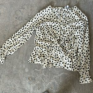 Cream and black blouse. Elastic around wrist. One button in back.